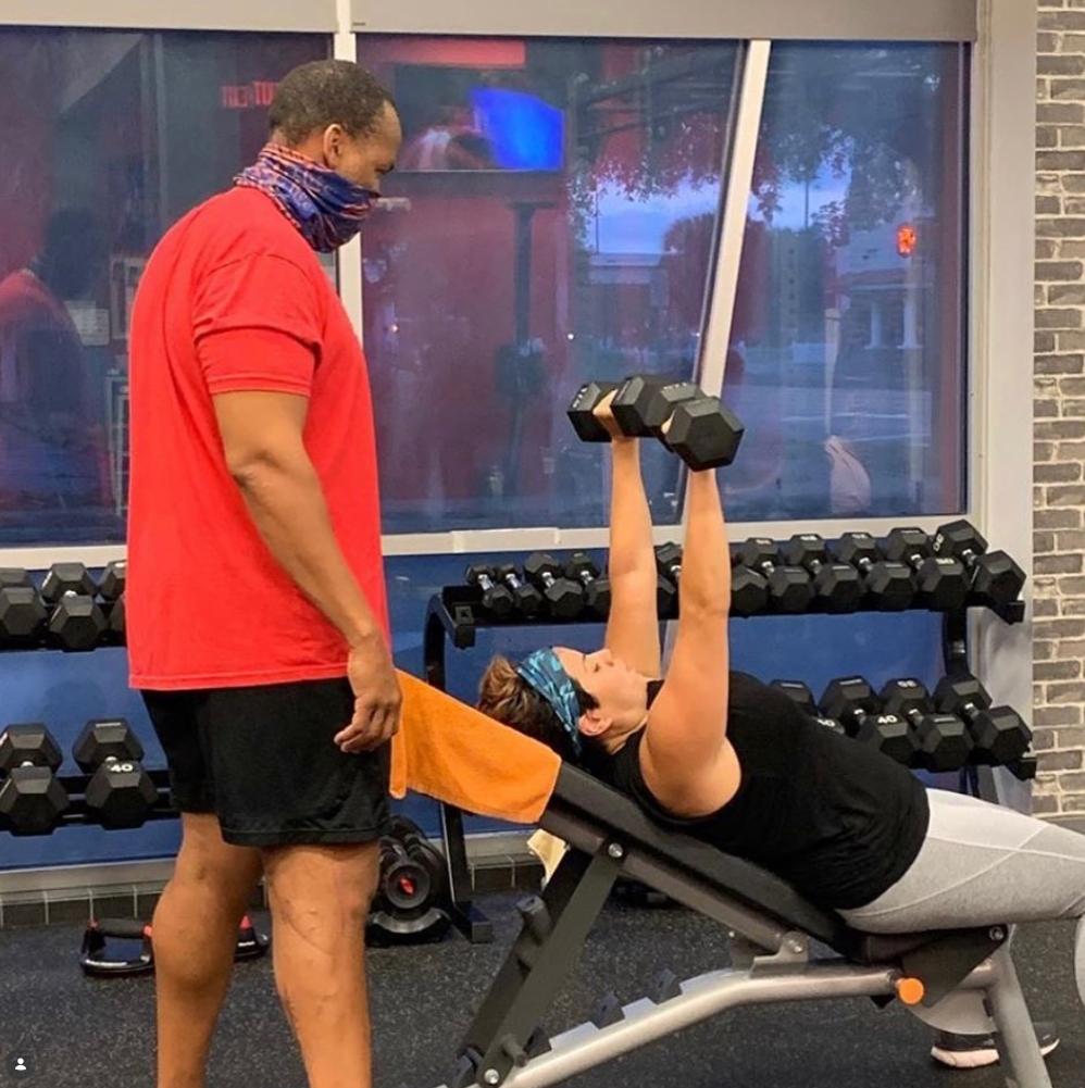 Ed Chester coaching a client through a dumbbell press exercise
